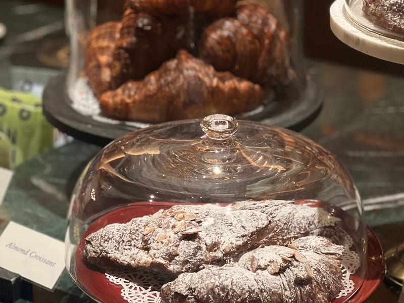 A croissant dusted with sugar on a plate